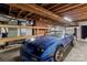 Basement featuring concrete floor, exposed ceiling, brick feature, and partially-visible blue car at 24501 Canton Rd, Albemarle, NC 28001