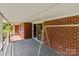 Covered porch featuring brick accents, sliding glass doors, and cozy outdoor space at 24501 Canton Rd, Albemarle, NC 28001
