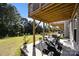 Covered backyard patio with outdoor seating and view of a lush, green backyard and surrounding trees at 2665 Grantham Place Dr, Fort Mill, SC 29715