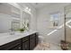 Bright bathroom featuring double sinks, modern fixtures, and a tiled shower with a glass door at 2665 Grantham Place Dr, Fort Mill, SC 29715