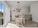 Dining area with wood floors, a modern chandelier, a table with four chairs, and a sliding glass door at 2665 Grantham Place Dr, Fort Mill, SC 29715
