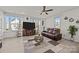 Spacious living room featuring a large window, ceiling fan, comfortable brown leather seating, and a decorative rug at 2665 Grantham Place Dr, Fort Mill, SC 29715