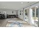 Bright living room with hardwood floors, modern furniture, and a sliding glass door leading to an outdoor area at 2665 Grantham Place Dr, Fort Mill, SC 29715