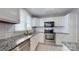 Well-lit kitchen featuring granite countertops, stainless steel appliances, and modern white cabinetry at 2715 Selwyn Ave # 36, Charlotte, NC 28209