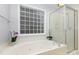 Bright bathroom featuring a glass block window, soaking tub, and glass-door shower at 2906 Chapman Cir, Rock Hill, SC 29732