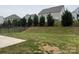 Backyard view shows a concrete patio, lawn with trees, and black metal fence at 3022 Burnello Ct, Iron Station, NC 28080