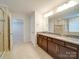 Bathroom featuring granite countertops, and sinks, and tiled shower with glass door at 3022 Burnello Ct, Iron Station, NC 28080