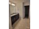 Bathroom showcasing double vanity, tile flooring, and doorway to walk-in closet at 3022 Burnello Ct, Iron Station, NC 28080