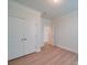Bright bedroom with crown molding, a closet with double doors and wood-look flooring at 3022 Burnello Ct, Iron Station, NC 28080