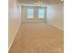 A sunlit bedroom features neutral walls, carpet, and two windows with blinds at 3022 Burnello Ct, Iron Station, NC 28080