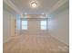 Bright bedroom with tray ceiling, neutral carpet, and double windows allowing for ample natural light at 3022 Burnello Ct, Iron Station, NC 28080