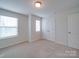 Bedroom featuring neutral walls, carpet, closet, and two large windows at 3022 Burnello Ct, Iron Station, NC 28080