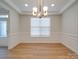 Dining room with decorative trim, a tray ceiling, chandelier, and wood-look flooring at 3022 Burnello Ct, Iron Station, NC 28080