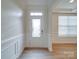 Bright entryway featuring a decorative glass front door, wainscoting, and wood-look flooring at 3022 Burnello Ct, Iron Station, NC 28080
