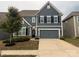 Charming two-story home with a blue facade, black shutters, attached two-car garage, and tidy landscaping at 3022 Burnello Ct, Iron Station, NC 28080