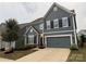 Attractive two-story home featuring a blue exterior, black shutters, two-car garage, and manicured landscaping at 3022 Burnello Ct, Iron Station, NC 28080