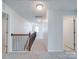 Hallway features neutral carpet and wood railing staircase at 3022 Burnello Ct, Iron Station, NC 28080