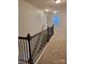 Hallway featuring neutral carpet, with wooden railing and spindles leading downstairs at 3022 Burnello Ct, Iron Station, NC 28080