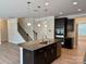 Open concept kitchen with island, granite countertops, and stainless steel appliances; adjacent to staircase at 3022 Burnello Ct, Iron Station, NC 28080