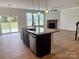Kitchen island with seating and sink overlooks the living room and fireplace in this open concept home at 3022 Burnello Ct, Iron Station, NC 28080