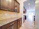 Close up of kitchen featuring dark cabinets with granite countertops and tile backsplash at 3022 Burnello Ct, Iron Station, NC 28080