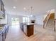 Bright, open kitchen featuring a granite island, stainless appliances, and a view of the living area at 3022 Burnello Ct, Iron Station, NC 28080