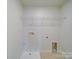 Bright laundry room with tile floor and wire rack for organizing your laundry needs at 3022 Burnello Ct, Iron Station, NC 28080