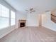 Bright living room with stone fireplace, ceiling fan, and large windows providing natural light at 3022 Burnello Ct, Iron Station, NC 28080