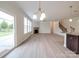 Open-concept living room featuring a stone fireplace, large windows, and sliding glass doors to backyard at 3022 Burnello Ct, Iron Station, NC 28080