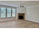Sunlit living room with stone fireplace, neutral walls, and large windows, offers a cozy atmosphere at 3022 Burnello Ct, Iron Station, NC 28080