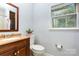 Bathroom featuring a wood vanity with a sink, a toilet, and a window for natural light at 3049 Stablegate Dr, Gastonia, NC 28052