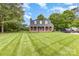 Charming brick home with a well-manicured lawn, mature trees, and a long driveway, perfect for a peaceful living at 3049 Stablegate Dr, Gastonia, NC 28052