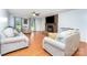 Open living room with hardwood floors, brick fireplace, comfortable seating, and large windows that allow natural light at 3049 Stablegate Dr, Gastonia, NC 28052