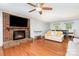 Spacious living room featuring hardwood floors, a brick fireplace, comfortable seating, and dining area for entertaining at 3049 Stablegate Dr, Gastonia, NC 28052