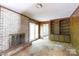 A damaged living room featuring a brick fireplace, built-in shelves, French doors, and wood paneling at 3316 Fairhaven Rd, Rock Hill, SC 29732