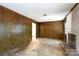 Living room with wood paneling, brick fireplace, a window, and damaged hardwood flooring at 3316 Fairhaven Rd, Rock Hill, SC 29732