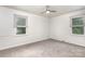Bright bedroom with neutral carpet, ceiling fan, and two windows offering natural light at 3555 Tree Line Dr, Rock Hill, SC 29732