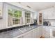 Efficient kitchen sink area with tile backsplash, white cabinets, and natural light from a window at 403 Carpenter Parker Ln, Rock Hill, SC 29730