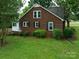 Rear view of a charming brick home with black shutters, a well-maintained lawn, and mature trees at 4098 S Nc Hwy 127 Hwy, Hickory, NC 28602