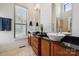 Elegant bathroom featuring dual sinks, wood cabinets, granite countertops, and a large window at 411 Steel Gardens Blvd, Charlotte, NC 28205
