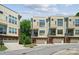 Modern townhome showcasing a brick and light yellow facade, garage, and small balcony at 411 Steel Gardens Blvd, Charlotte, NC 28205