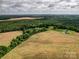 Aerial view of an expansive land parcel featuring mature trees and open agricultural fields at 4111 Jenkins Rd, Marshville, NC 28103