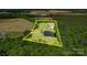 Aerial view of the home's acreage with pond, surrounded by mature trees and open fields at 4111 Jenkins Rd, Marshville, NC 28103