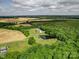 An aerial view showcasing a well-manicured property with pond and mature trees amid agricultural land at 4111 Jenkins Rd, Marshville, NC 28103