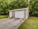 Outbuilding with garage door and entrance door with concrete parking pad at 4111 Jenkins Rd, Marshville, NC 28103