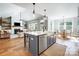 Spacious kitchen island with sink opens up to the living room and dining area, enhanced by hardwood floors at 4116 Spring Cove Way, Belmont, NC 28012
