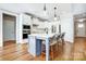 A modern kitchen island featuring barstool seating, pendant lighting, and hardwood floors at 4116 Spring Cove Way, Belmont, NC 28012