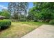 Spacious backyard with a large grassy area and mature trees surrounding the property at 4220 Castlewood Rd, Charlotte, NC 28209