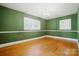 Green bedroom with natural light and hardwood floors at 4220 Castlewood Rd, Charlotte, NC 28209
