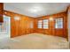 Cozy bonus room featuring knotty pine walls, a window, and an exterior door at 4220 Castlewood Rd, Charlotte, NC 28209